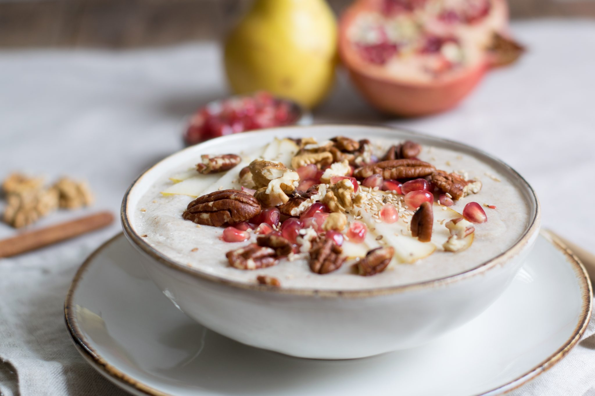 Eine Schule gefüllt mit Porridge und dekoriert mit Granatäpfel und Nüssen.